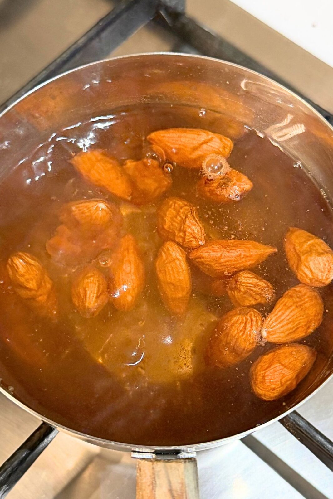 Almonds blanching in hot water to loosen their brown skins.