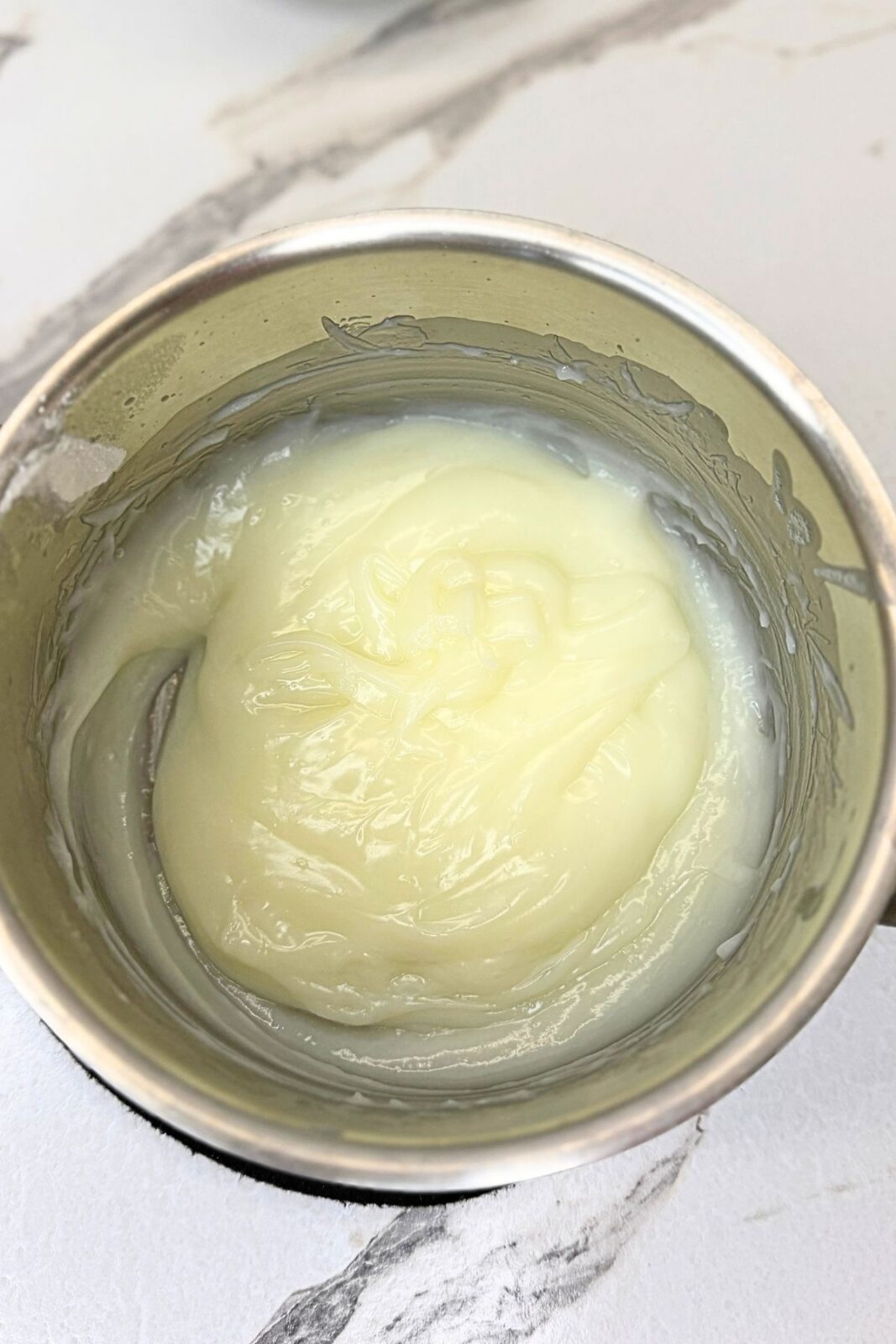 Thick, smooth milk cream in a saucepan for the Raffaello coconut ball filling.