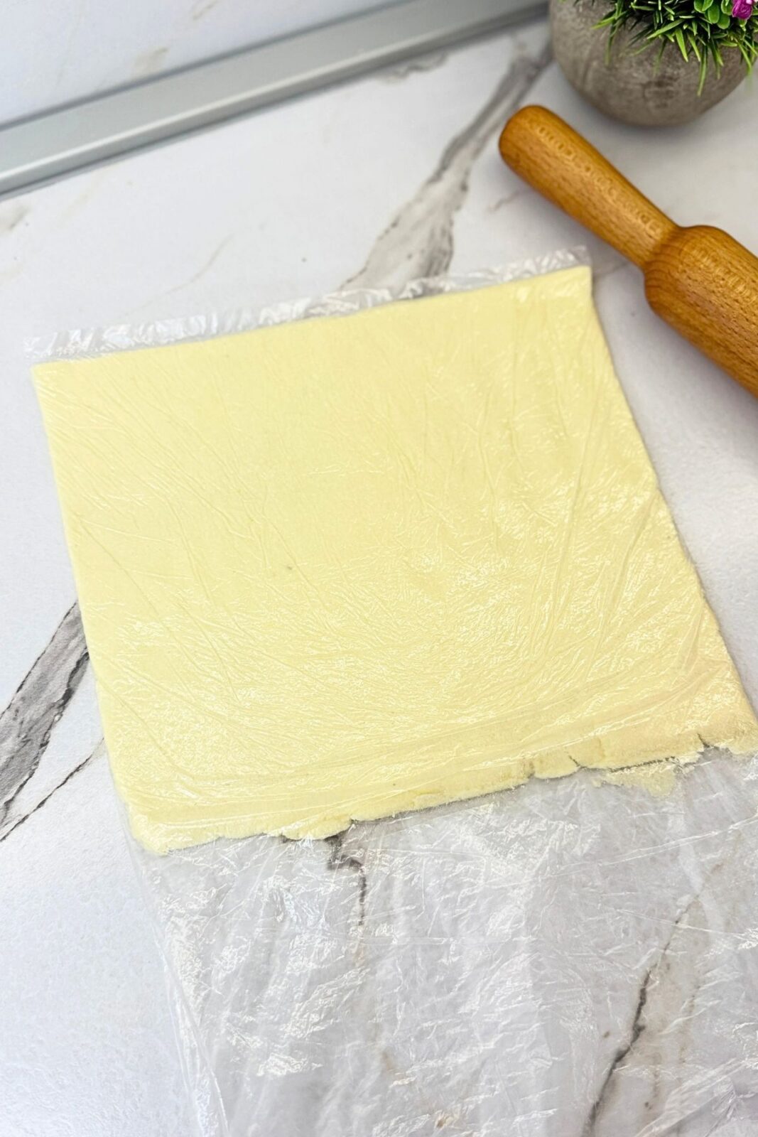 Coconut filling rolled into an even rectangle inside a freezer bag for chocolate coconut roll.
