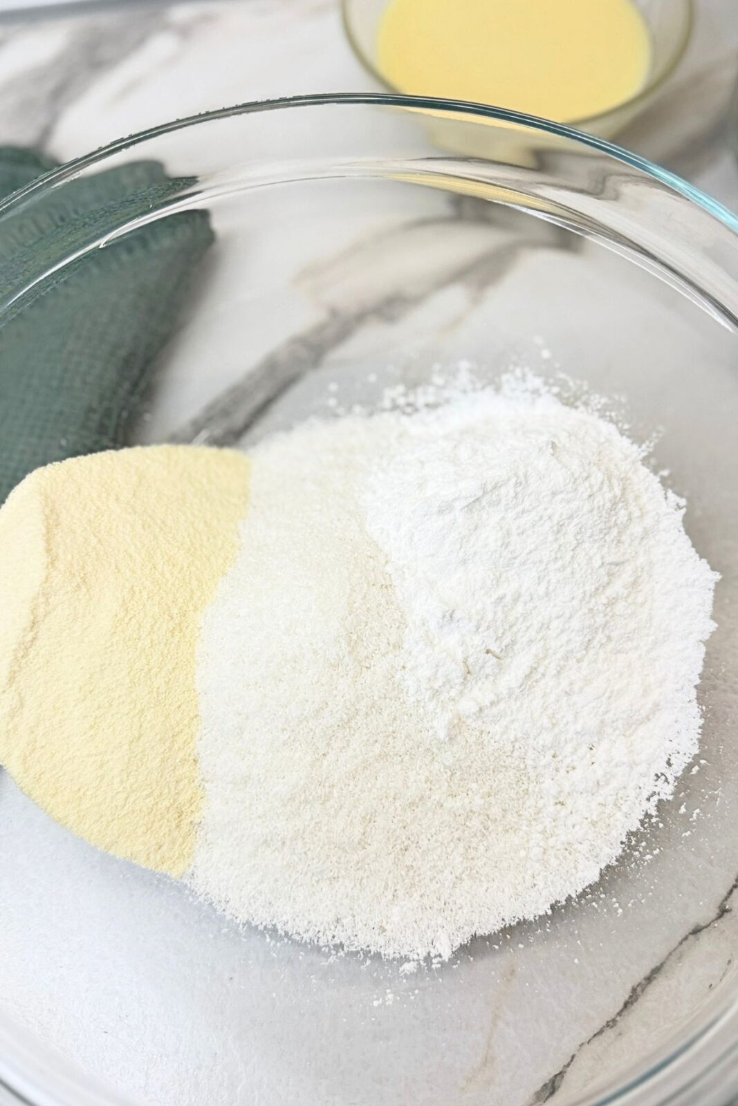 Powdered sugar, desiccated coconut, and milk powder in a glass bowl for making homemade bounty bars.