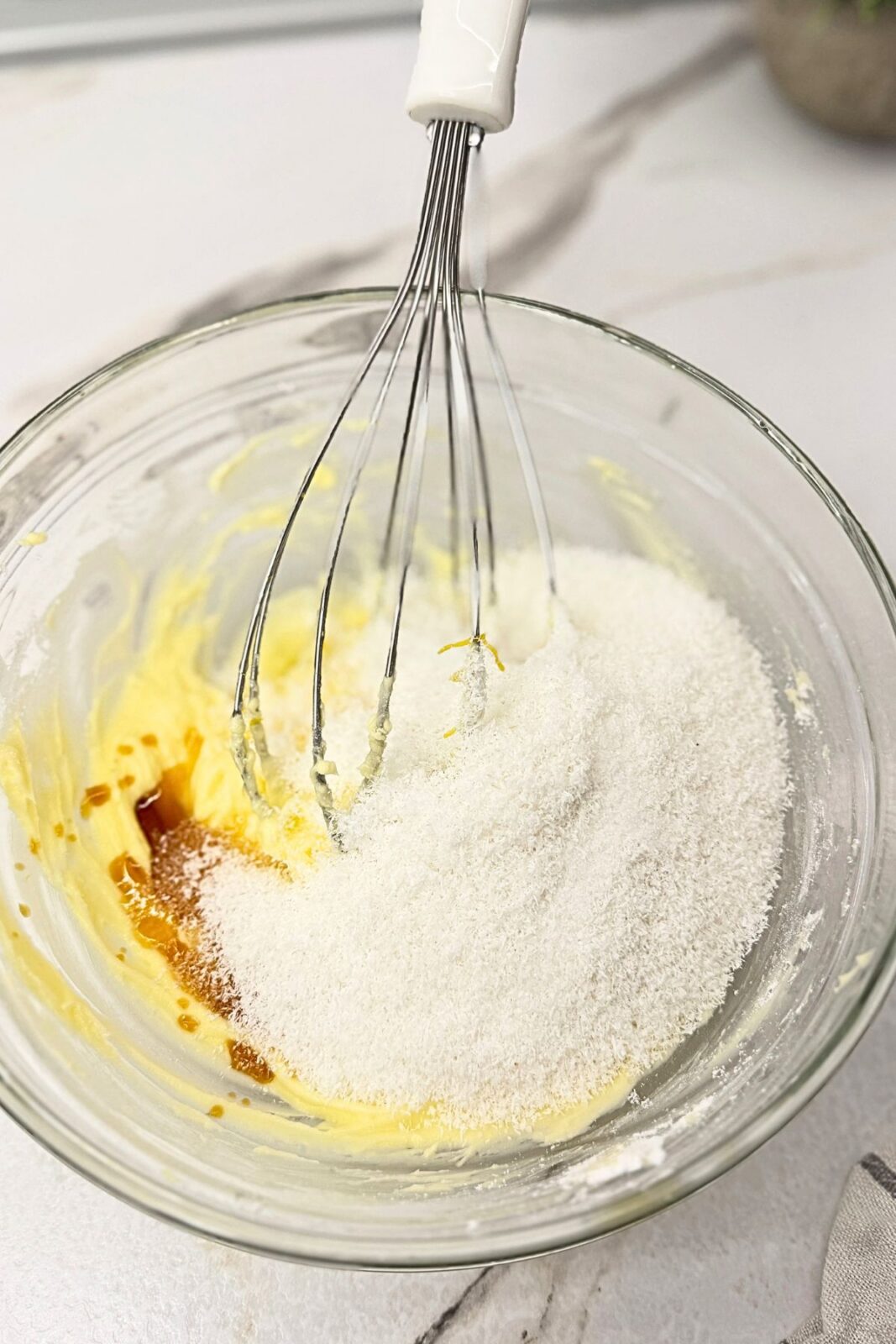 ## How to Make Lemon Coconut Shortbread Cookies

### 1. Cream the Butter and Sugar
Beat the softened butter until pale and fluffy. Add the powdered sugar, vanilla extract, and lemon zest, then beat until smooth and well combined. Scrape down the sides of the bowl so everything mixes evenly.

### 2. Mix the Dough
Add the lemon juice, salt, and coconut, mixing until evenly distributed. Gradually add the flour and mix just until a soft dough forms. Scrape the bottom of the bowl to incorporate any remaining flour, and avoid overmixing once the dough comes together.

### 3. Chill for 30 Minutes
Cover the bowl and refrigerate the dough for **30 minutes**. This short rest firms up the butter and makes the dough easier to scoop and shape.

Meanwhile, preheat your oven to **350°F (175°C)** and line a baking sheet with parchment paper.

### 4. Shape and Bake
Scoop **1 tablespoon of dough per cookie** and gently roll each portion into a ball. Arrange on the prepared baking sheet, leaving about 2 inches between cookies.

Bake the lemon coconut shortbread cookies for **14 minutes**, until set and lightly golden underneath. The tops should remain pale; avoid waiting for them to brown all over.

### 5. Cool Completely
Let the cookies rest on the baking sheet for about 5 minutes before carefully transferring them to a wire rack. They will be delicate while warm, so handle them gently.

Allow them to cool completely before glazing.

### 6. Prepare the Lemon Glaze
Whisk the powdered sugar, lemon juice, and milk in a small bowl until smooth. The glaze should be thick enough to coat the tops of the cookies while still flowing easily for dipping.

### 7. Dip and Sprinkle with Coconut
Dip the top of each cooled cookie into the lemon glaze. Lift it out, let the excess drip back into the bowl, and place it upright on a wire rack.

Immediately sprinkle with coconut while the glaze is still wet so it sticks. Let the glaze set before stacking or storing your lemon coconut shortbread cookies.