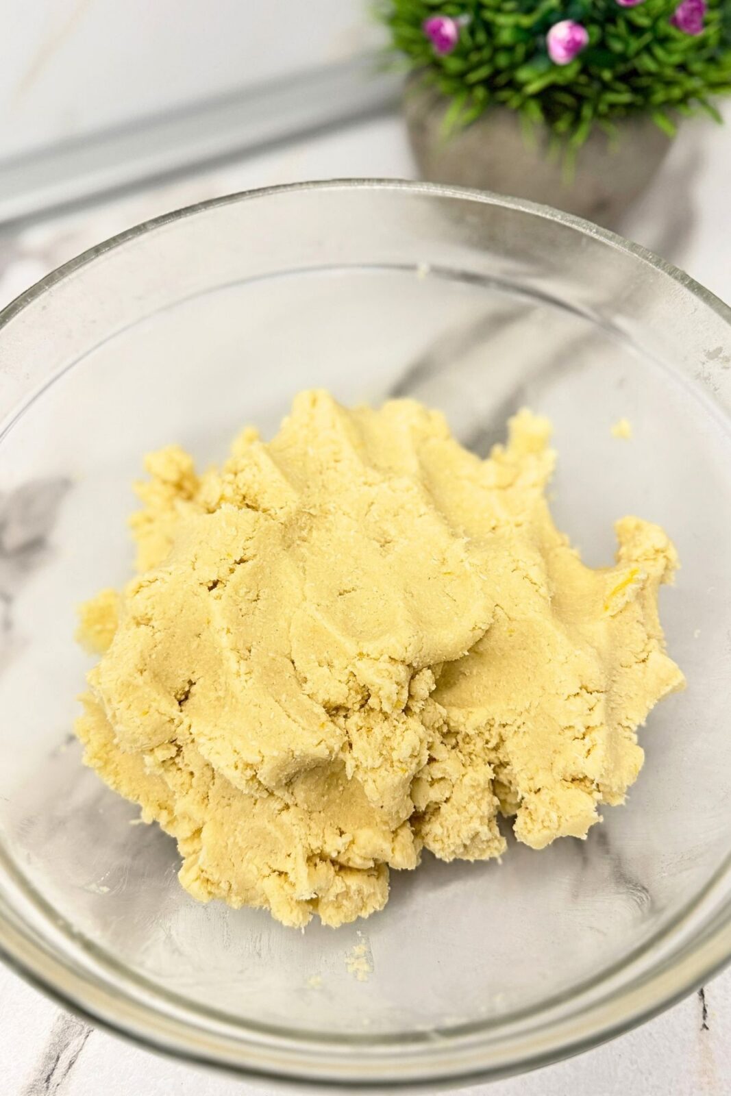 Lemon coconut shortbread cookie dough mixed together in a glass bowl.