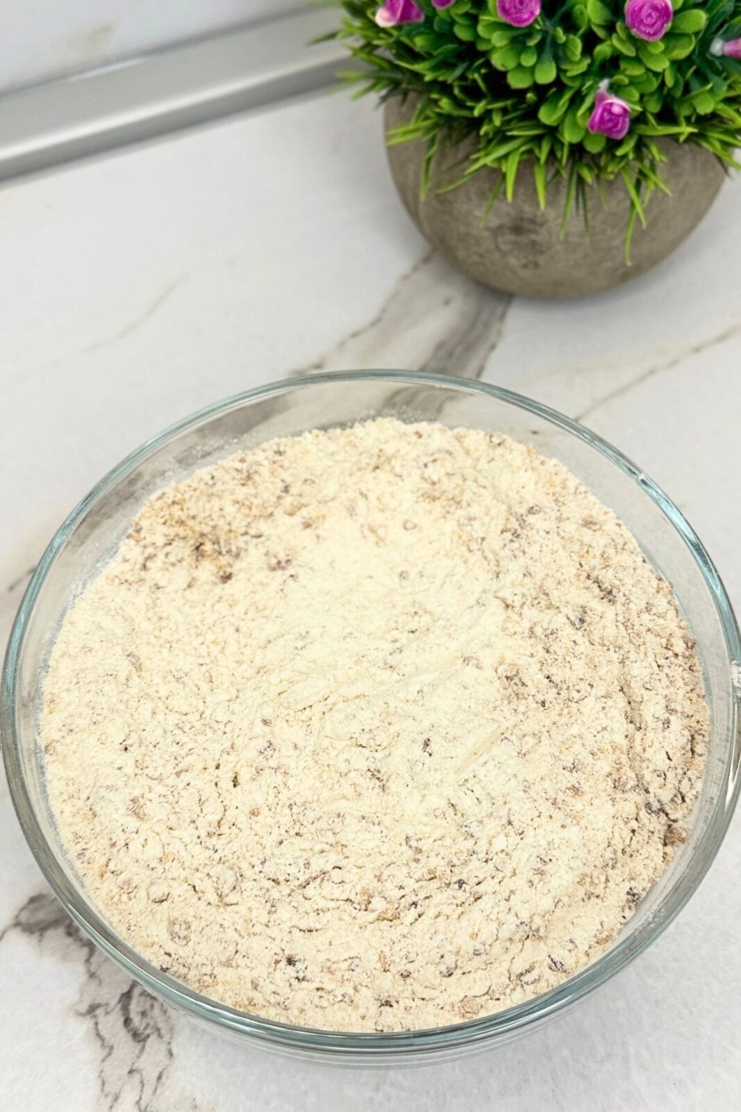 Flour mixture with ground toasted almonds in a glass bowl for Linzer cookie dough.