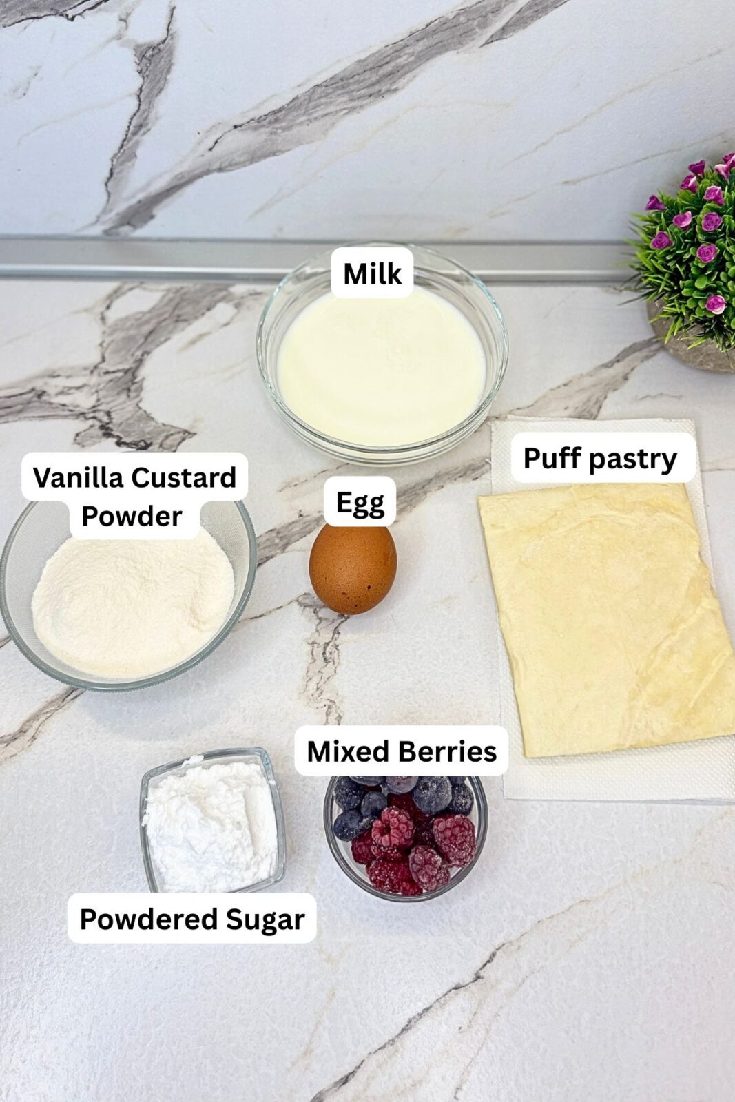 Ingredients for puff pastry cups with vanilla cream: puff pastry, egg, milk, vanilla cream powder, powdered sugar, blueberries, and raspberries.