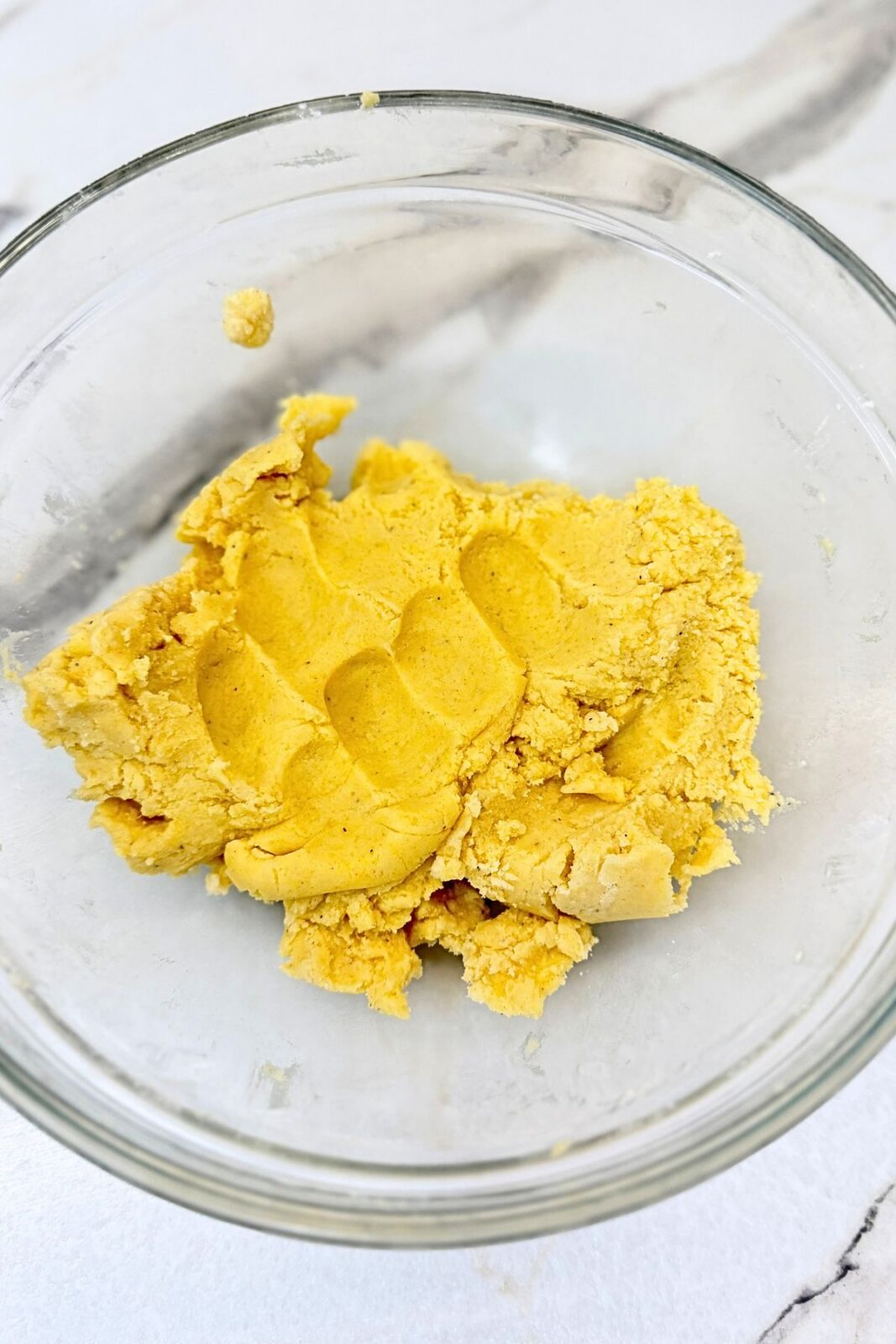 Vanilla crescent cookie dough mixed together in a glass bowl before shaping.